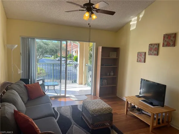 a living room with furniture a ceiling fan and a window