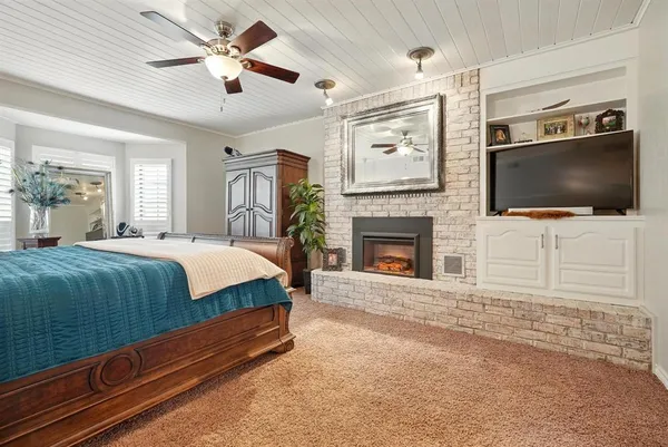 a spacious bedroom with a bed and a flat screen tv