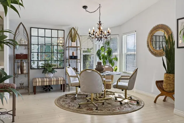 a view of a dining room with furniture a chandelier and wooden floor