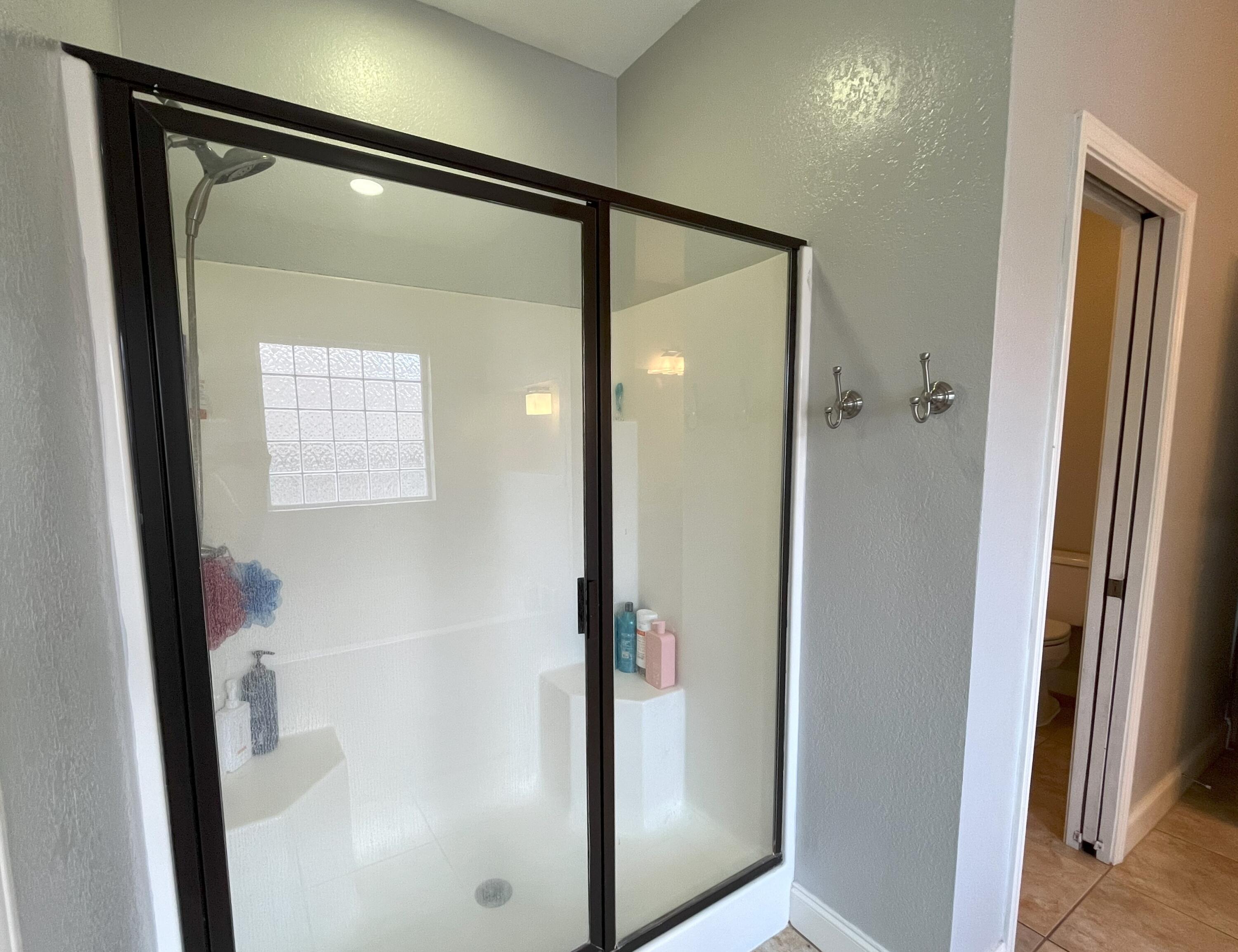 4589 Hermosa Road Crestview, FL 32539 - Photo 18 of 34 a bathroom with a glass shower door and a mirror