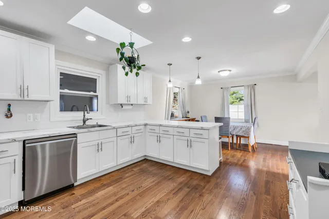 a kitchen with a sink cabinets and wooden floor