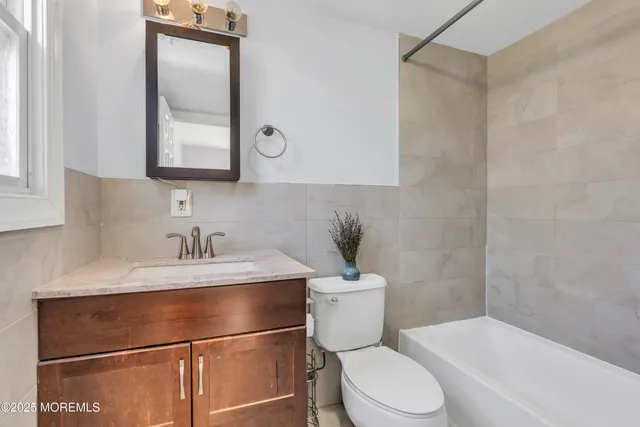a bathroom with a granite countertop sink mirror vanity and toilet