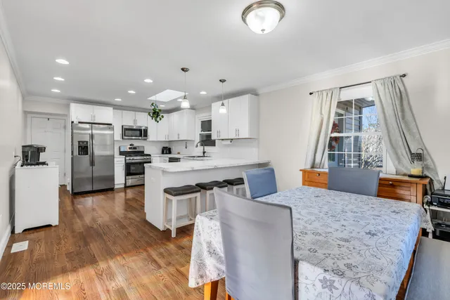 a kitchen with stainless steel appliances granite countertop a refrigerator a stove and a wooden floors