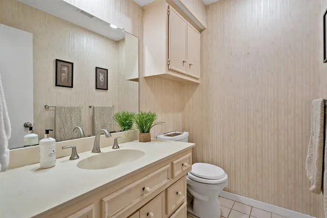 a bathroom with a granite countertop sink mirror vanity and toilet