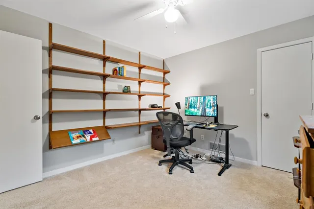 a view of a workspace with furniture and a window