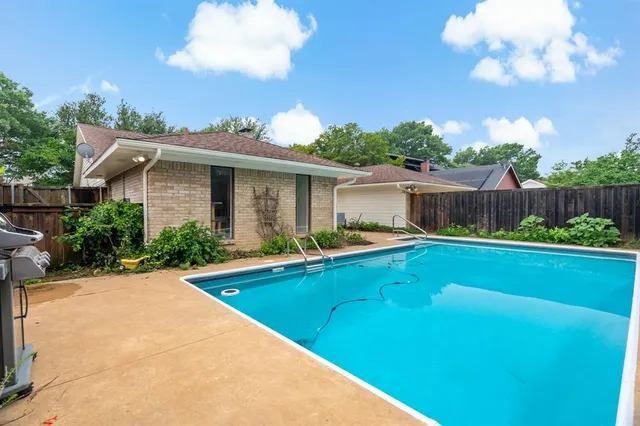 a view of a house with swimming pool and a yard