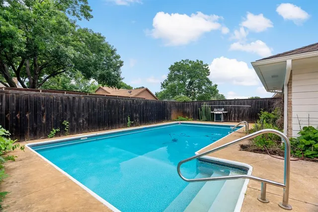 a view of a backyard with swimming pool and furniture
