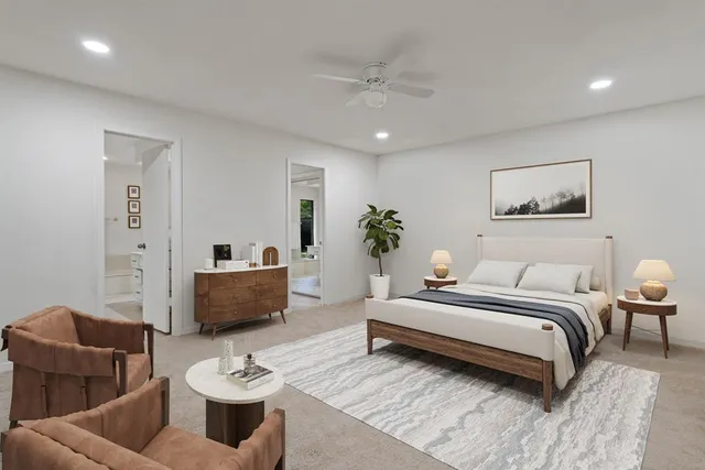 a spacious bedroom with a bed a couch and a potted plant