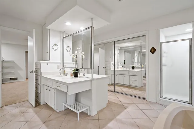 a bathroom with a sink a toilet a mirror and shower