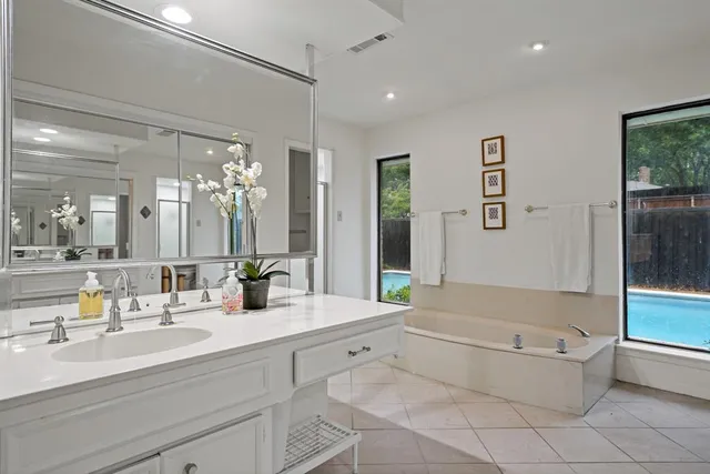 a bathroom with a large tub sink vanity and toilet
