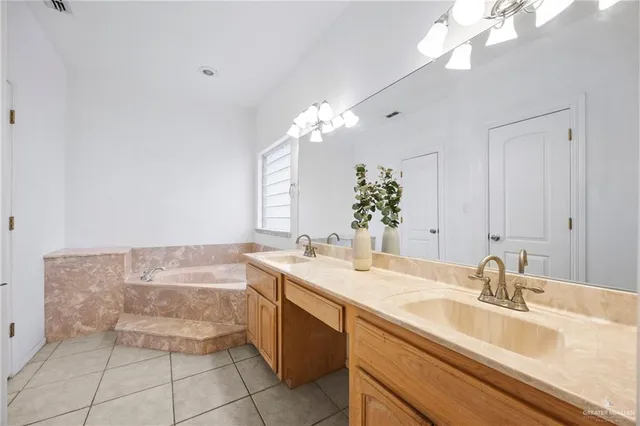 a bathroom with a sink vanity granite tub and a mirror
