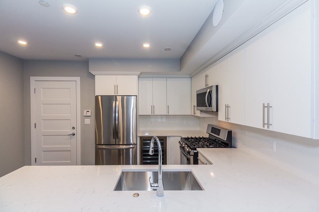 a kitchen with stainless steel appliances a refrigerator and a stove top oven