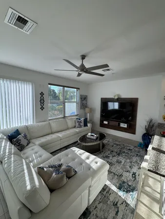 a living room with furniture a flat screen tv and a fireplace