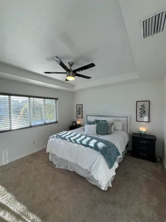 a spacious bedroom with a bed and a large window