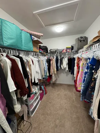 a view of walk in closet with clothes