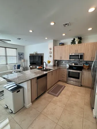 a large kitchen with a large counter top stainless steel appliances and cabinets
