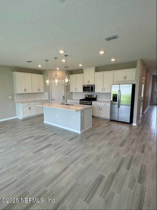 299 Cherry Elm Drive St. Augustine, FL 32092 - Photo 5 of 18 a large kitchen with stainless steel appliances granite countertop a large counter top and a stove top oven