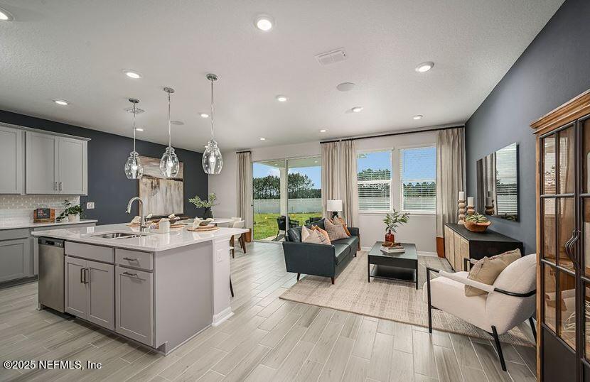 299 Cherry Elm Drive St. Augustine, FL 32092 - Photo 9 of 18 a view of kitchen with stainless steel appliances granite countertop a stove top oven a sink dishwasher and white cabinets with wooden floor
