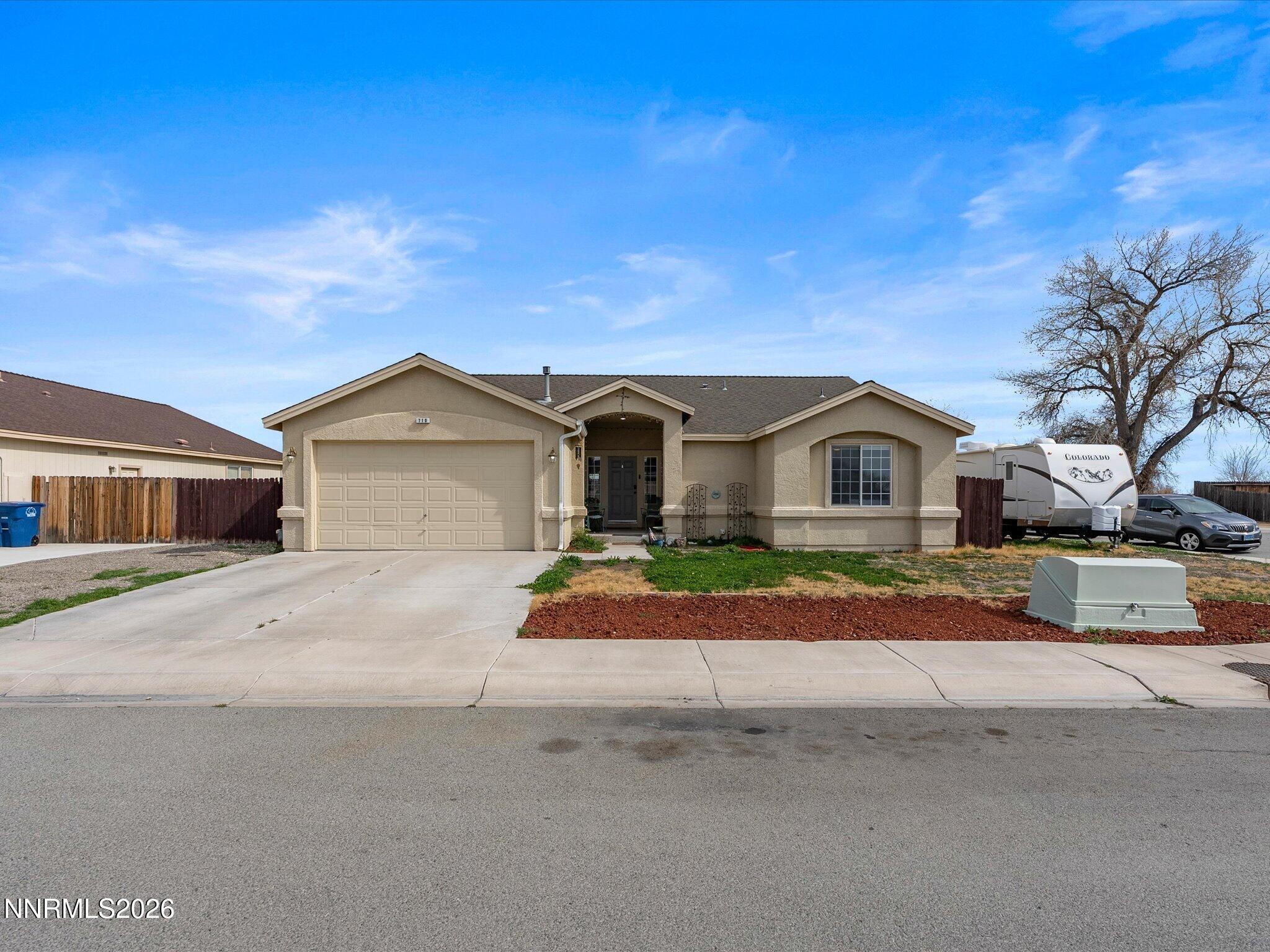 710 Keppel Street Fallon, NV 89406 - Photo 2 of 38 a front view of a house with a yard and garage