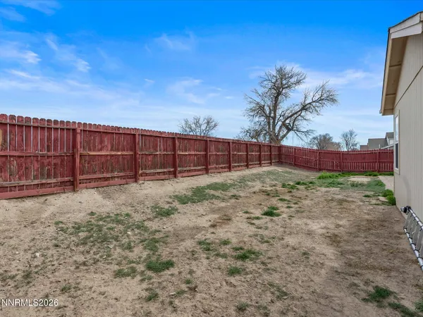 a view of backyard with wooden fence