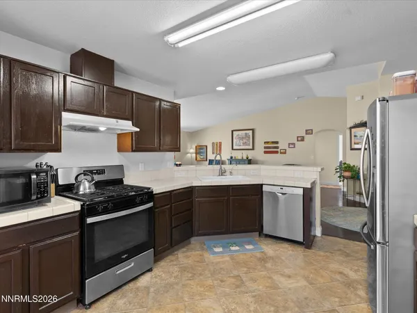a kitchen with stainless steel appliances granite countertop a stove sink and refrigerator