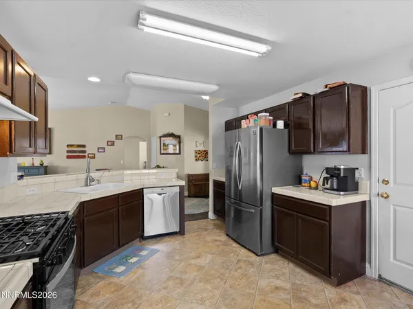 a kitchen with stainless steel appliances a sink stove refrigerator and cabinets