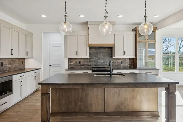 a large kitchen with granite countertop a stove a sink a oven and a granite counter tops