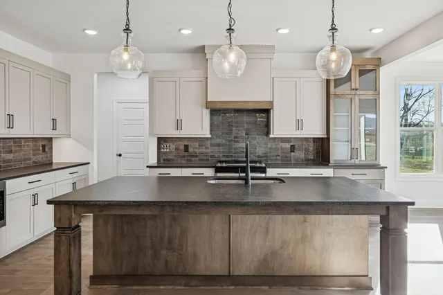 a large kitchen with kitchen island a large counter space wooden floor and appliances