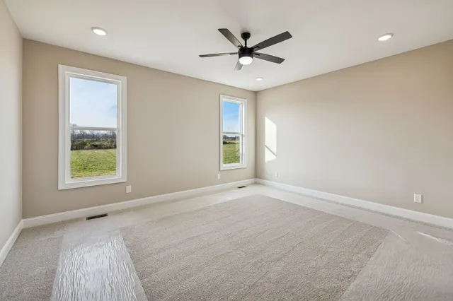 an empty room with closet and a ceiling fan