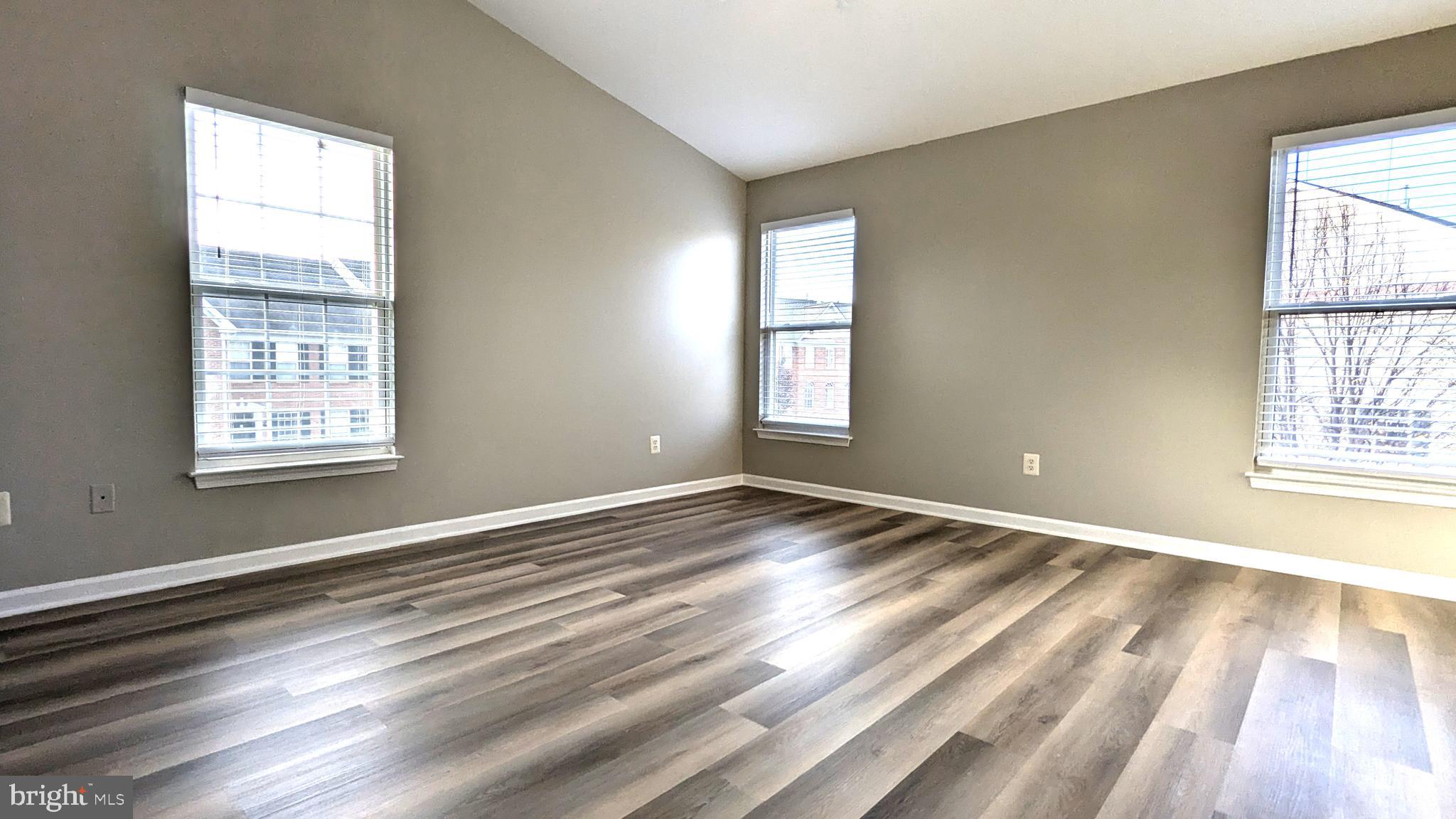 21506 Trowbridge Square Ashburn, VA 20147 - Photo 21 of 66 a view of an empty room with wooden floor and a window