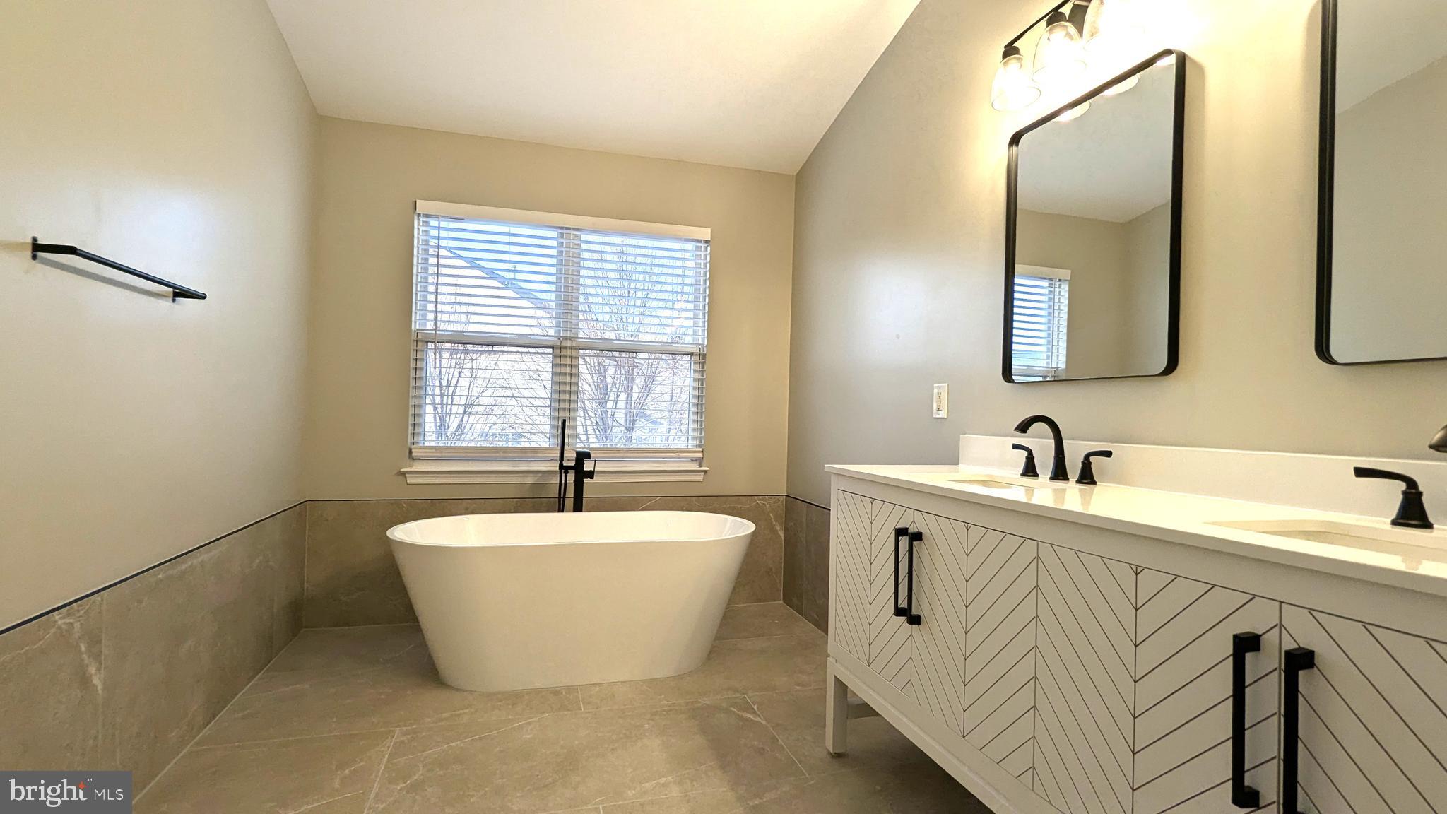 21506 Trowbridge Square Ashburn, VA 20147 - Photo 27 of 66 a spacious bathroom with a bathtub sink and mirror