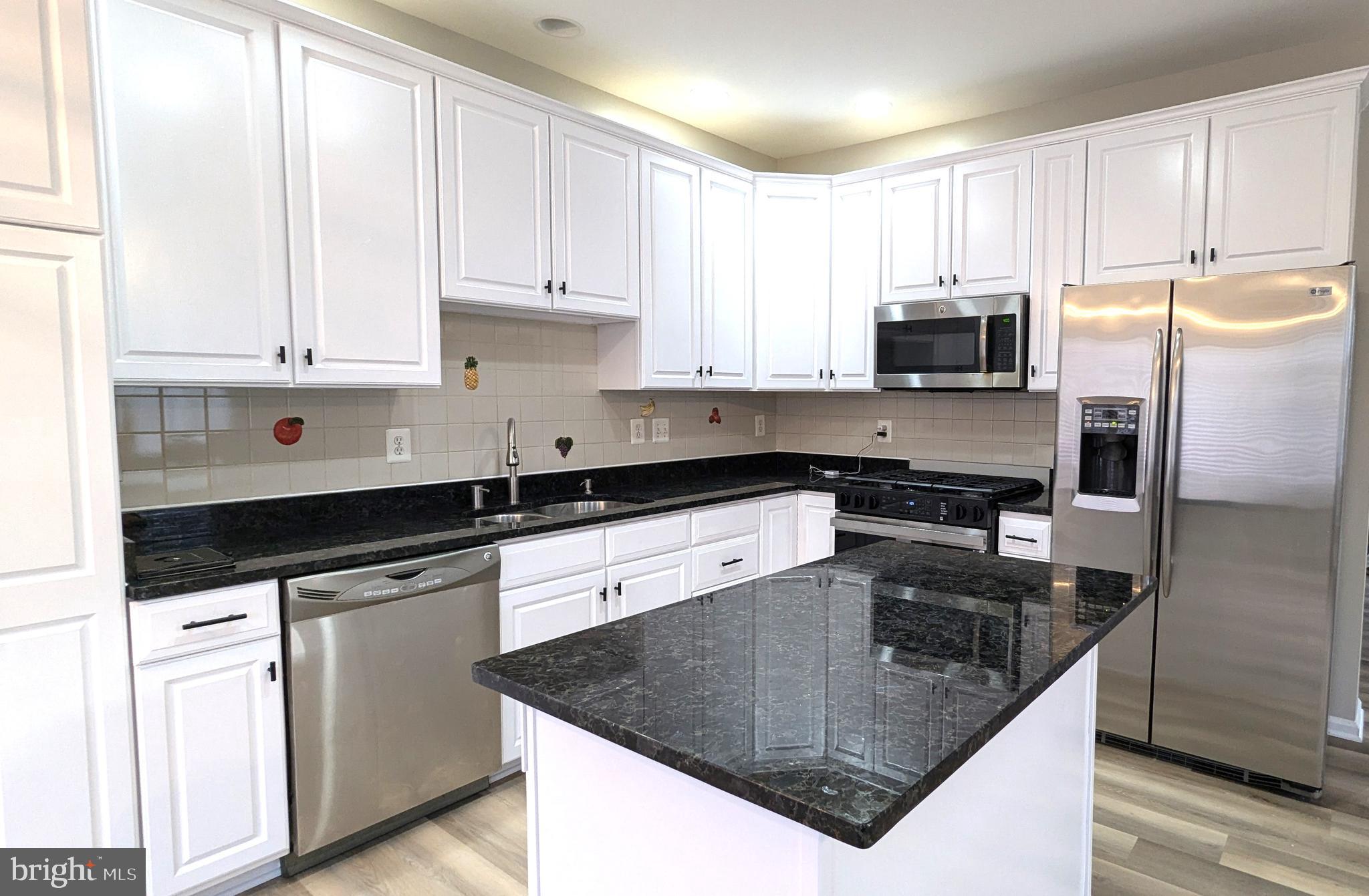 21506 Trowbridge Square Ashburn, VA 20147 - Photo 9 of 66 a kitchen with granite countertop a sink stove and refrigerator