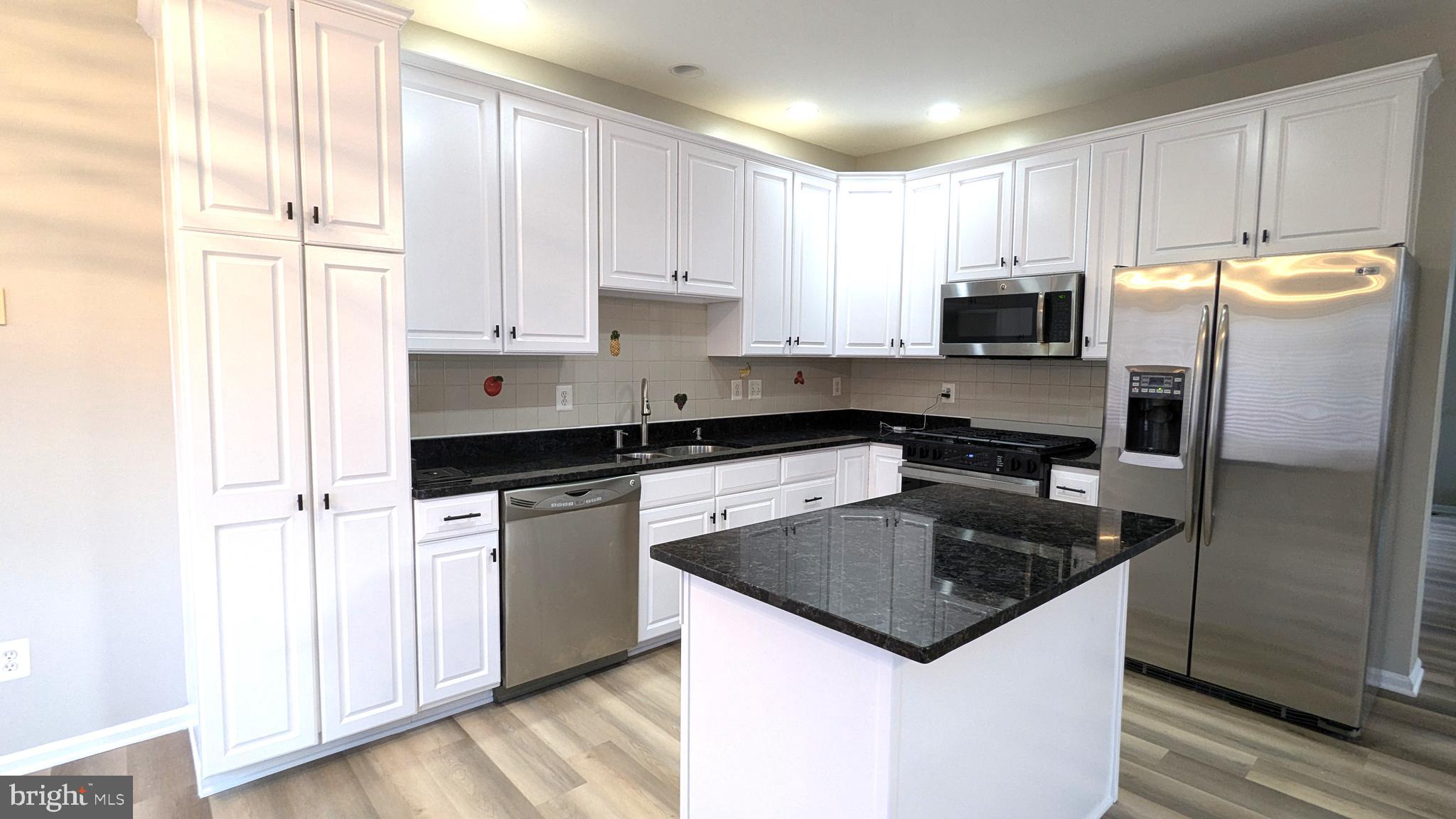 21506 Trowbridge Square Ashburn, VA 20147 - Photo 10 of 66 a kitchen with granite countertop a sink stove and refrigerator