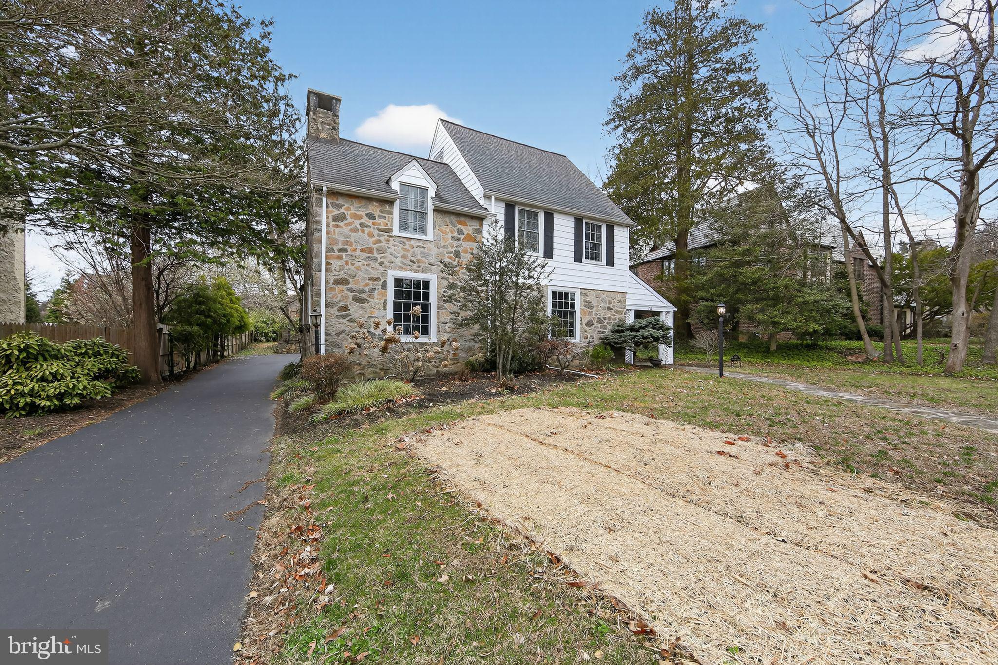 a front view of a house with a yard and trees