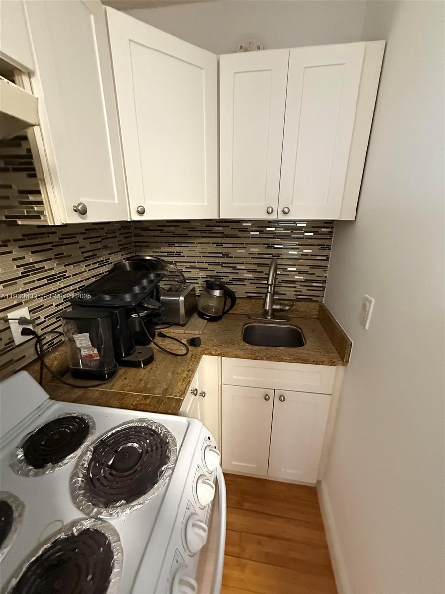 894 80th Street, Unit 1 Miami Beach, FL 33141 - Photo 2 of 13 a kitchen with a sink a stove and cabinets