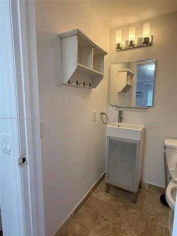 a bathroom with a sink toilet and mirror
