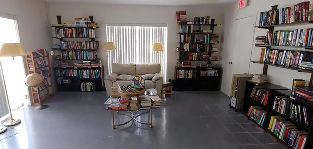a view of a patio with table and chairs potted plants and floor to ceiling window