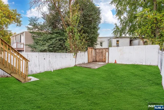 a view of a house with backyard and a garden