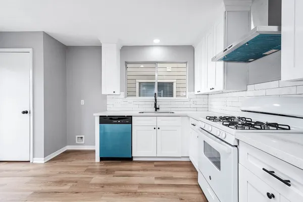 a kitchen with granite countertop white cabinets and white appliances