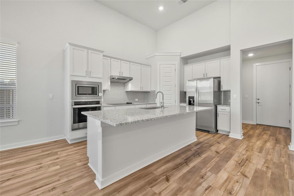 113 Shadow Oak Cove Georgetown, TX 78628 - Photo 10 of 40 A well-appointed culinary space featuring sleek stainless steel appliances and a central granite island.