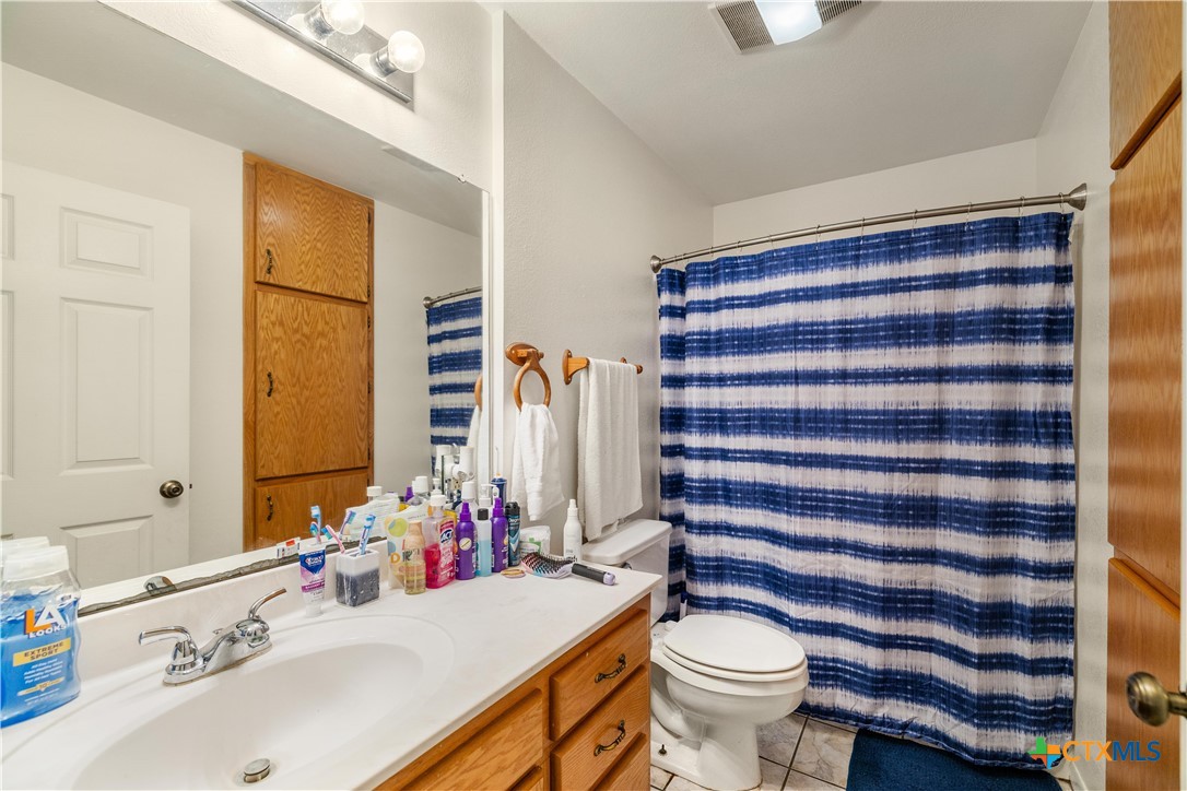 374-376 Navidad Street Vanderbilt, TX 77991 - Photo 11 of 28 a bathroom with a sink a toilet a mirror and shower curtain