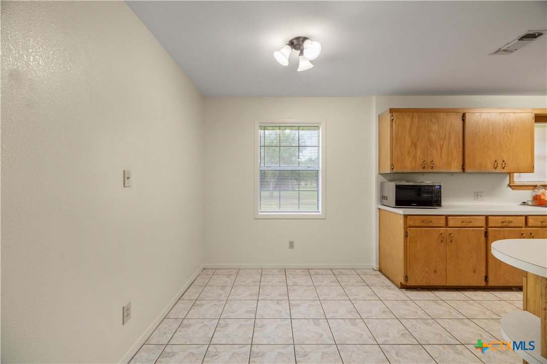 374-376 Navidad Street Vanderbilt, TX 77991 - Photo 18 of 28 a view of a kitchen with a stove cabinets and a window