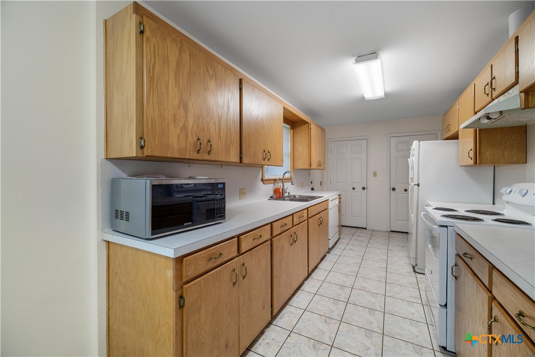 374-376 Navidad Street Vanderbilt, TX 77991 - Photo 19 of 28 a kitchen with stainless steel appliances a stove a sink and a microwave
