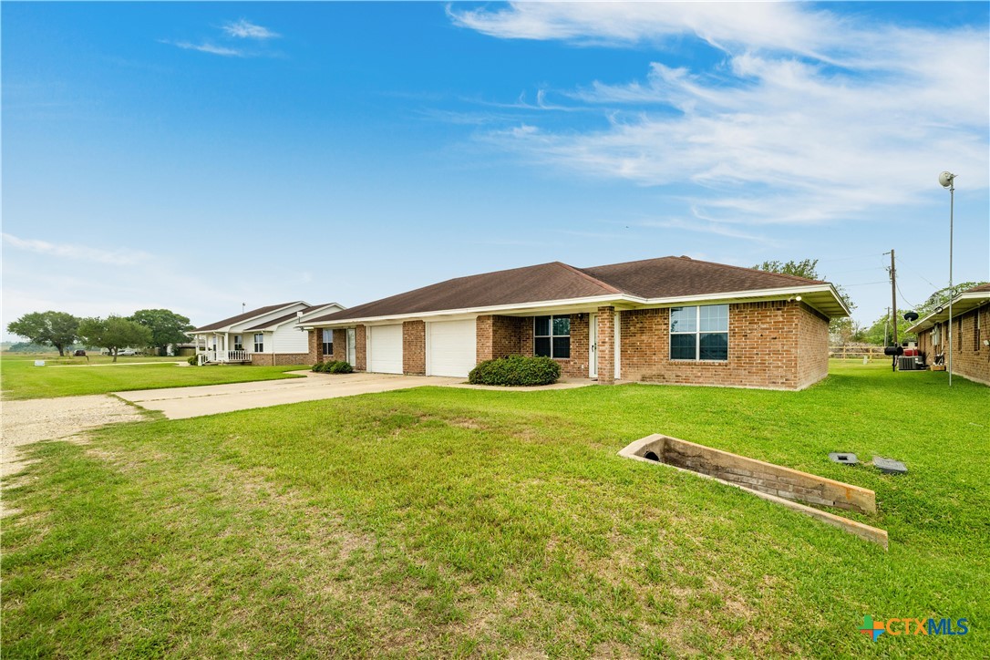 374-376 Navidad Street Vanderbilt, TX 77991 - Photo 28 of 28 a front view of a house with garden