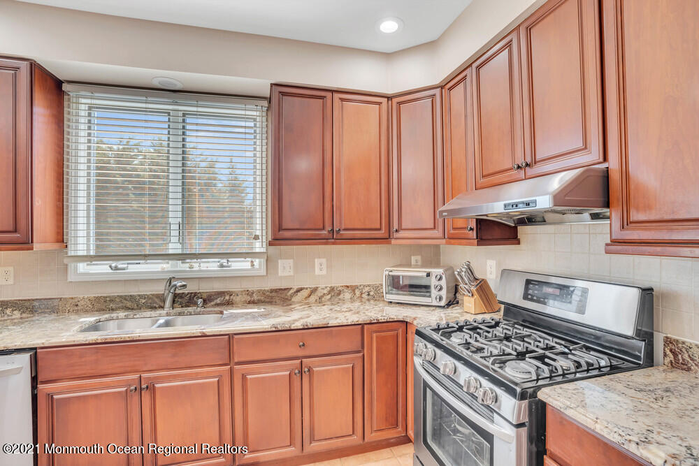 30 Red Oak Lane Freehold, NJ 07728 - Photo 24 of 73 a kitchen with granite countertop a sink a stove and cabinets