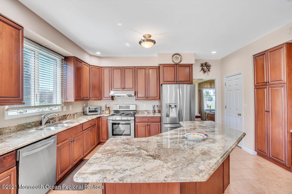 30 Red Oak Lane Freehold, NJ 07728 - Photo 26 of 73 a kitchen with kitchen island granite countertop a sink stove and refrigerator