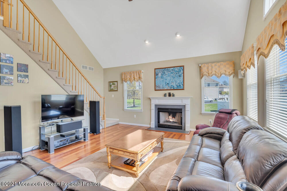 30 Red Oak Lane Freehold, NJ 07728 - Photo 32 of 73 a living room with furniture a flat screen tv and a fireplace