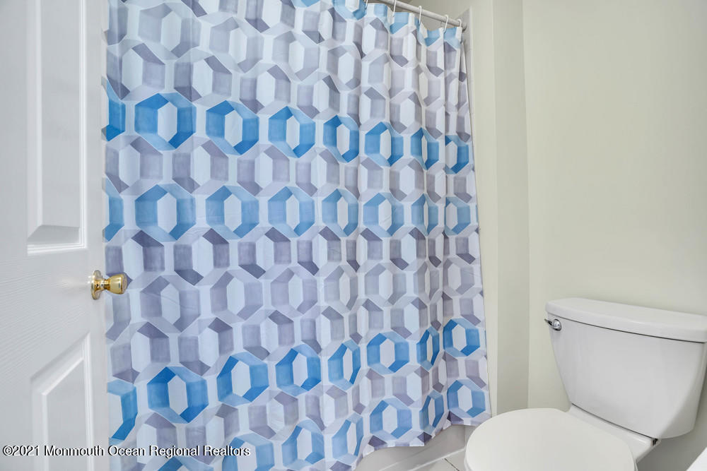 30 Red Oak Lane Freehold, NJ 07728 - Photo 39 of 73 a white toilet sitting next to a shower curtain