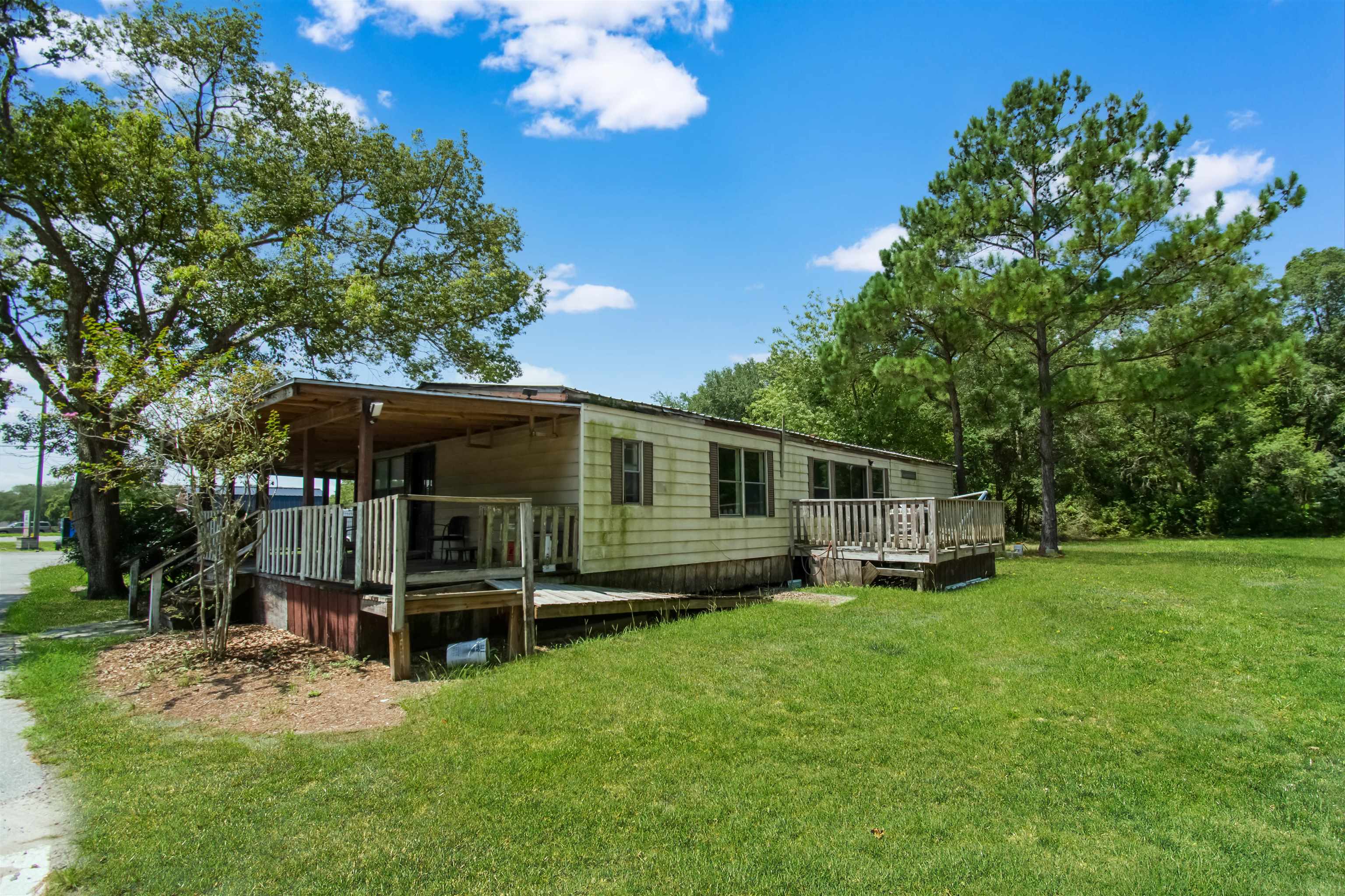 463493 State Road 200 Yulee, FL 32097 - Photo 11 of 20 a backyard of a house with wooden fence and large trees