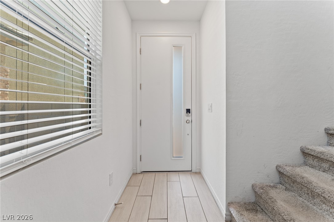 8879 Roadrunner Ravine Street Las Vegas, NV 89166 - Photo 3 of 39 A welcoming entry features light-toned flooring and a contemporary front door with a vertical glass insert.